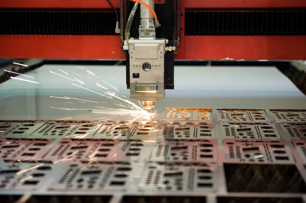 CNC laser cutting machine cutting precision metal parts in Toronto fabrication shop